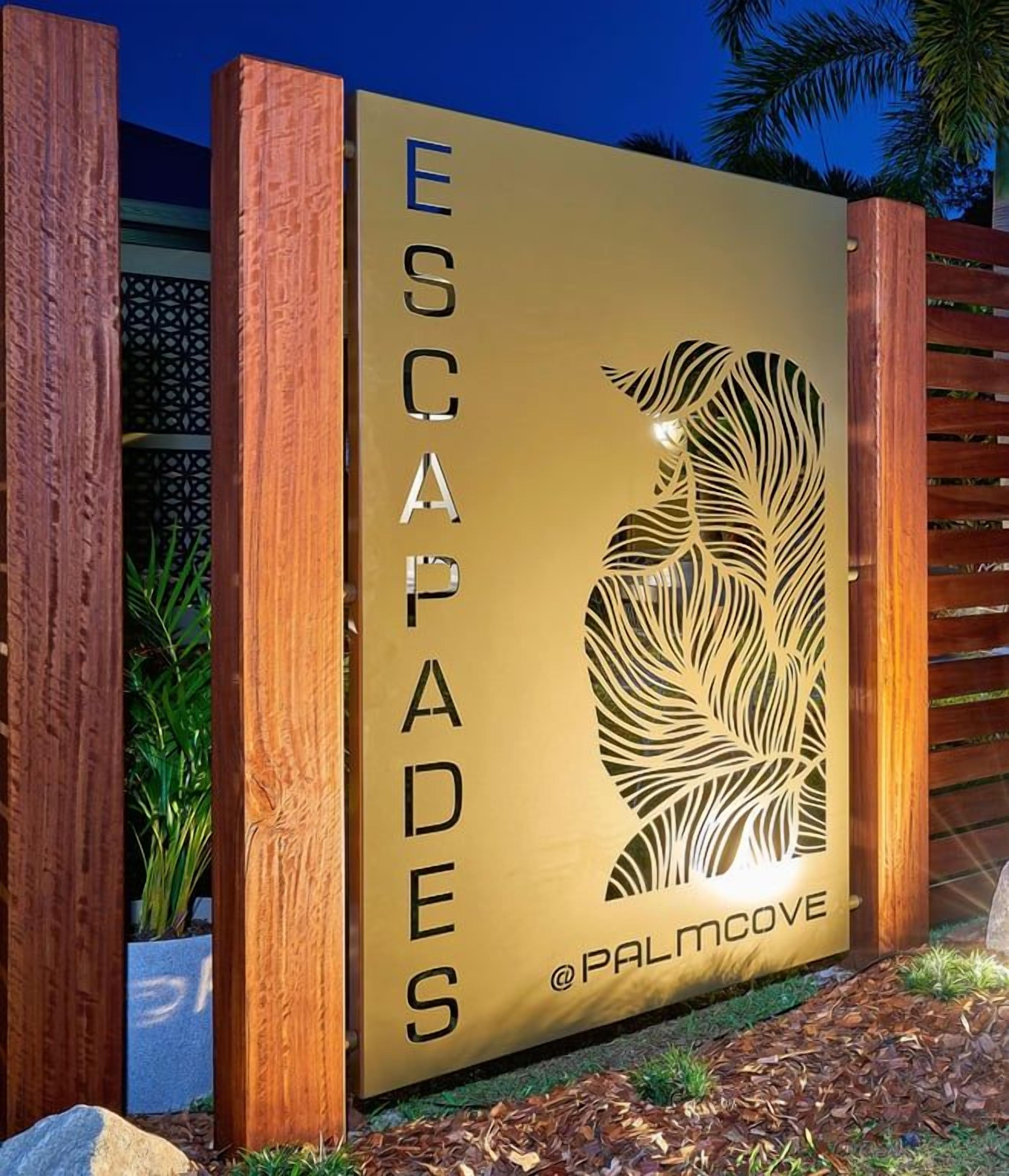 A sign with the text 'ESCAPADES' and a leaf design, indicating a themed area or section.
