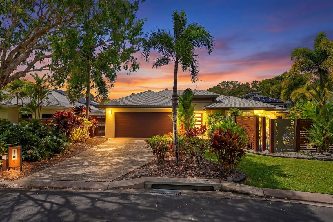 A residential property with a driveway, a garage, and a well-maintained lawn.