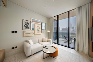 Ein modernes Wohnzimmer mit einer Couch, einem Couchtisch und einem großen Fenster mit Blick auf die Stadt.