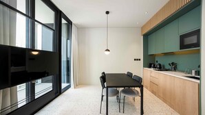 A modern kitchen with a dining table and chairs, a large window, and a pendant light. - Chic City Studio in Upside w/ Burj View (Dubai)