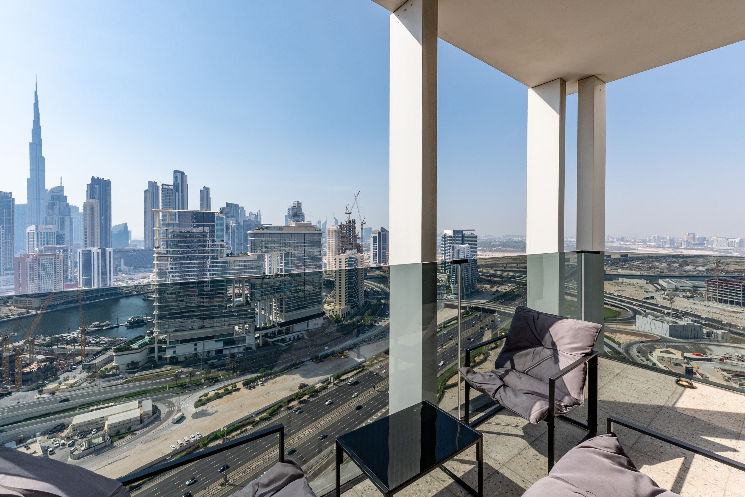 A high-rise building with a view of a city skyline, including a prominent tower.
