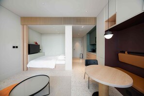 A modern hotel room with a bed, a desk, a chair, and a small table. - Executive Studio w/ Burj Khalifa View (Dubai)