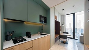 A modern kitchen with a built-in stove, a coffee maker, and a sink. - Contemporary Studio w/ Burj View (Dubai)