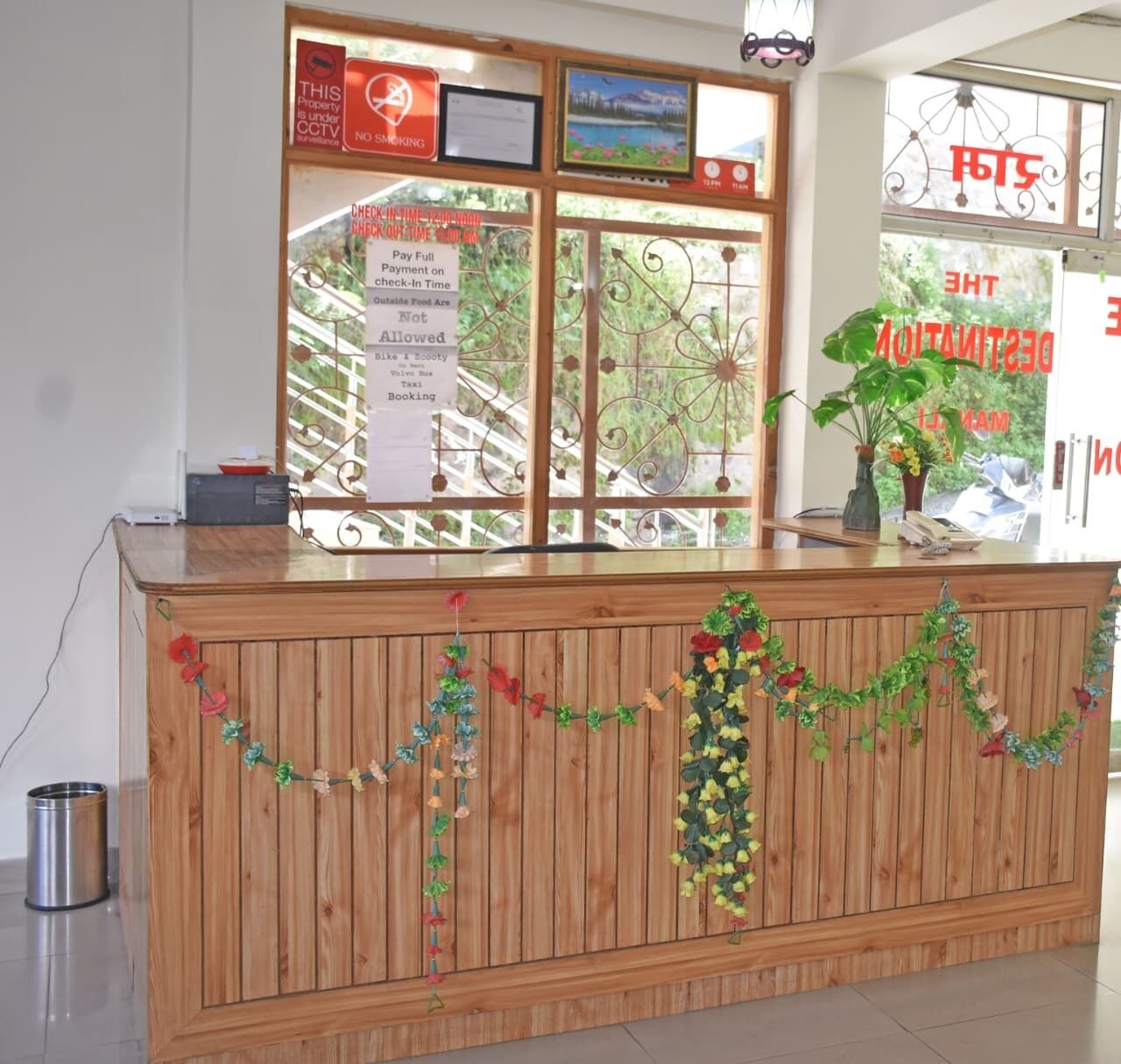 A reception desk with a wooden finish, decorated with floral garlands.