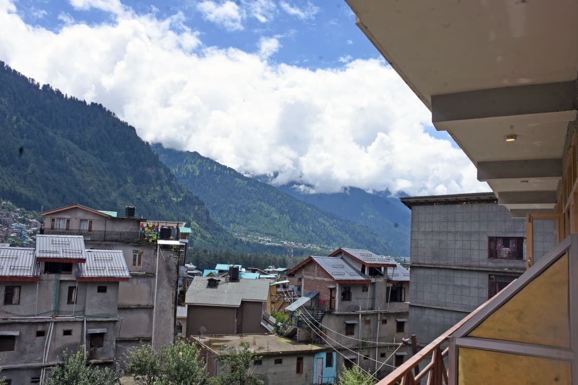 Zona residencial con edificios, montañas al fondo y cielo despejado.
