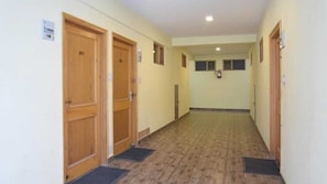 A corridor with wooden doors, numbered 201, and a tiled floor. - Hotel The Destination Manali (850m from Mall Road) (Manali)