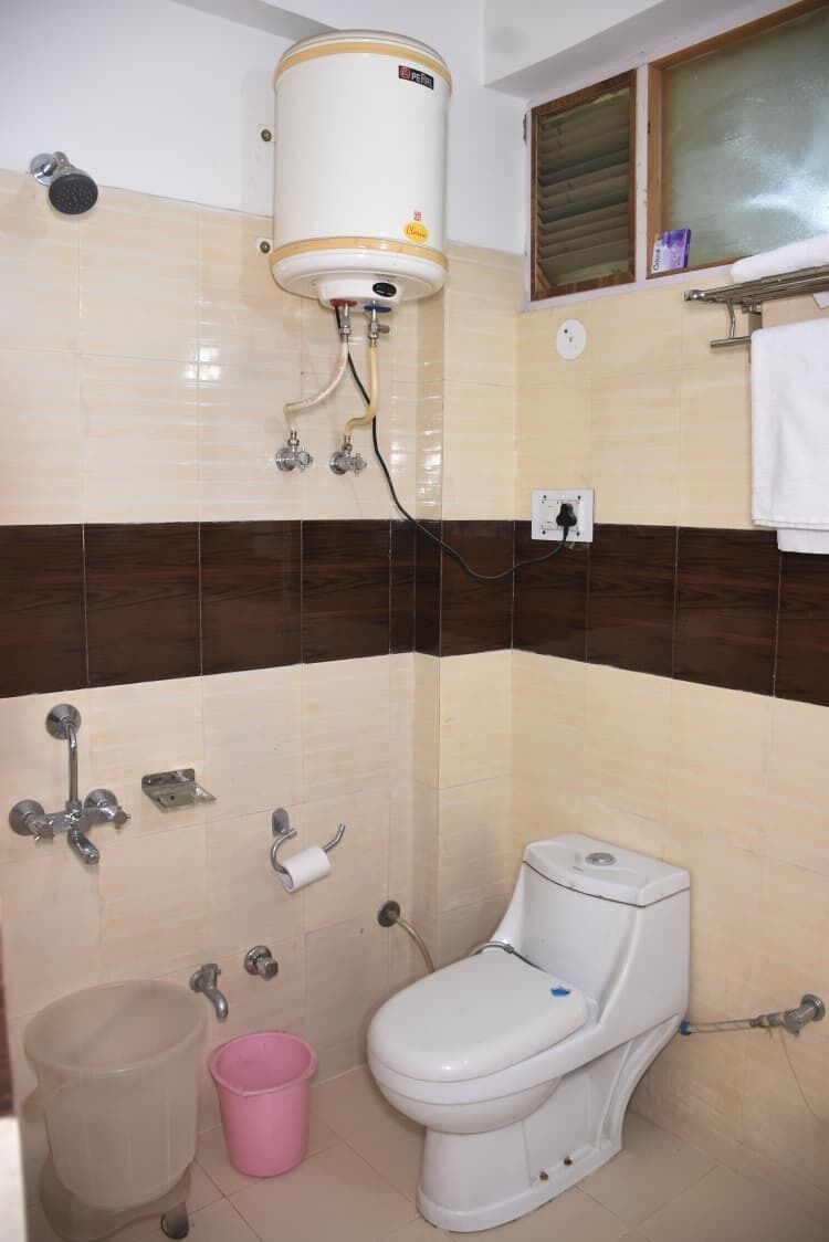 Un baño con inodoro, ducha y calentador de agua.