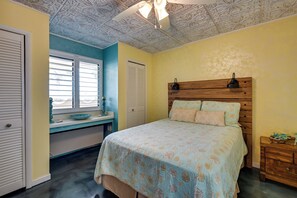 Ein Schlafzimmer mit einem Bett, einem Schreibtisch und einem Fenster.