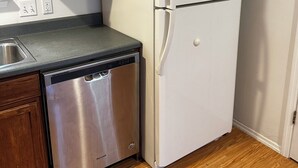 Eine Küche mit Holzschränken, einem weißen Kühlschrank, einem Edelstahl-Geschirrspüler und einer Arbeitsplatte.