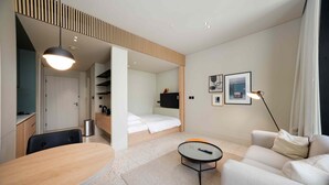 A modern hotel room with a bed, a desk, a sofa, and a small table. - Modern Upside Studio w Skyline View (Dubai)