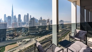 A high-rise building with a view of a city skyline, including a prominent tower. - Bright Studio w Iconic Burj View (Dubai)