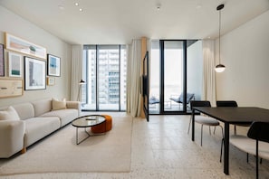 Ein modernes Wohnzimmer mit Sofa, Couchtisch und Essbereich.