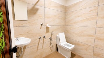 A modern bathroom with a shower, toilet, and sink.