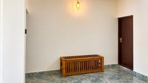 Ein Flur mit einer Bank, einer Tür und einer wandmontierten Leuchte.