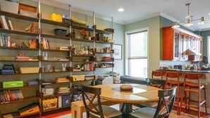 A dining area with a round table, chairs, and a bookshelf filled with books and decorative items. - Quiet Home in Walkable Area: 3 Mi to National Mall (Washington)