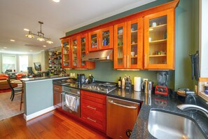 A modern kitchen with wooden cabinets, stainless steel appliances, and a central island. - Quiet Home in Walkable Area: 3 Mi to National Mall (Washington)