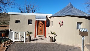 A two-story building with a distinctive wooden door and a corrugated metal roof. - Room-11 on High Airbnb za (Gariep)