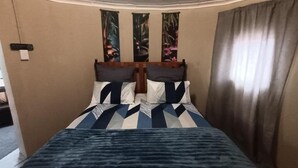 A hotel room with a bed, curtains, and wall decorations. - Room-11 on High Airbnb za (Gariep)