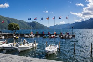 Ein Yachthafen mit vertäuten Booten, einer Anlegestelle und einer gebirgigen Kulisse.