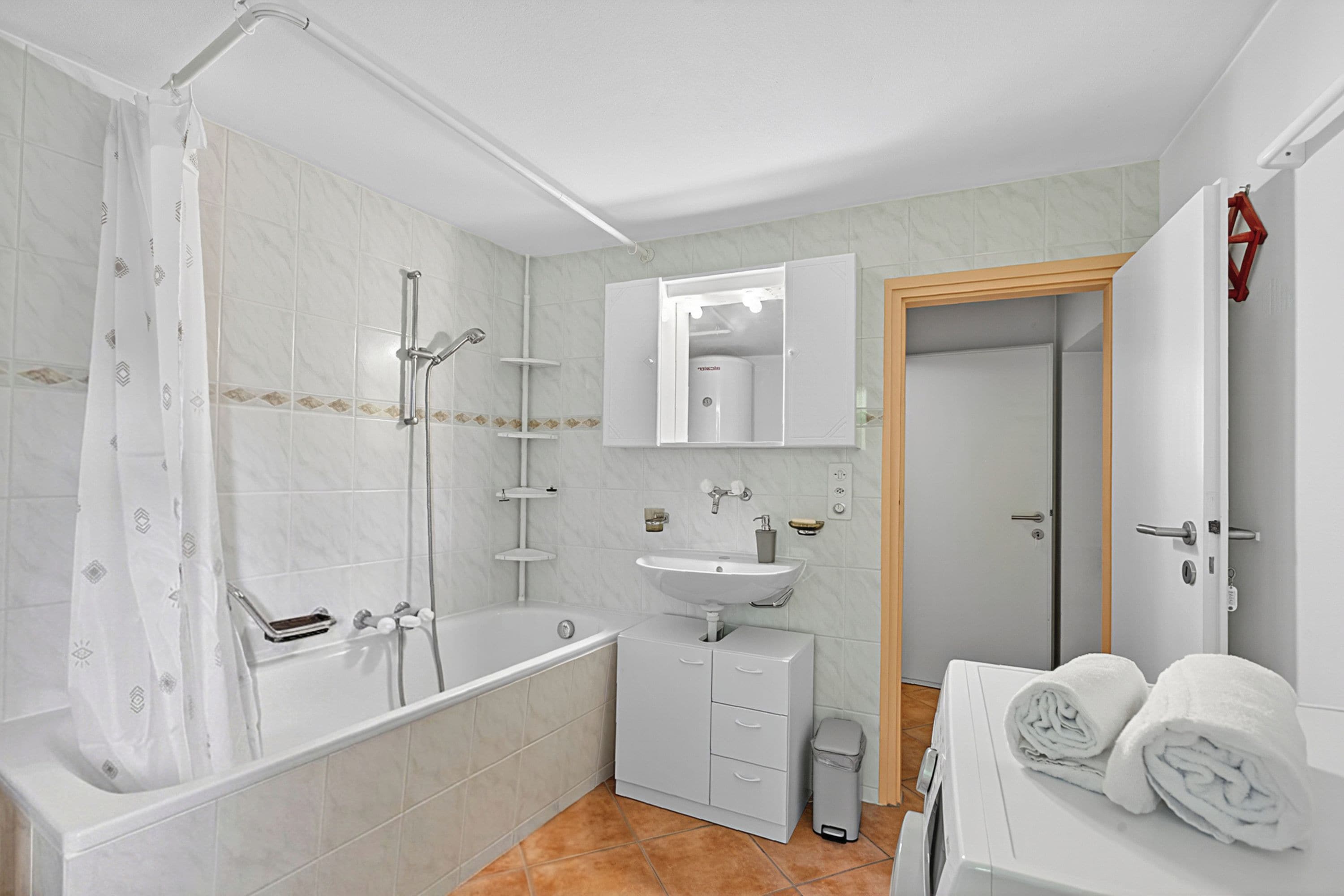 Une salle de bain avec une baignoire, un lavabo, un miroir et un porte-serviettes.
