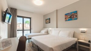 A hotel room with two beds, a desk, a chair, a TV, and artwork on the walls. - CENTRO HOTEL - MARCON (Marcon)