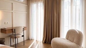 A modern bedroom with a bed, a desk, a chair, and a large window with curtains. - Meros Marotti | Spacious 3BR Home in Zakynthos (Zakinthos)