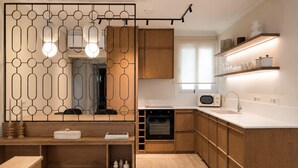 A modern kitchen with wooden cabinets, a built-in oven, a microwave, and a white countertop. - Meros Marotti | Spacious 3BR Home in Zakynthos (Zakinthos)