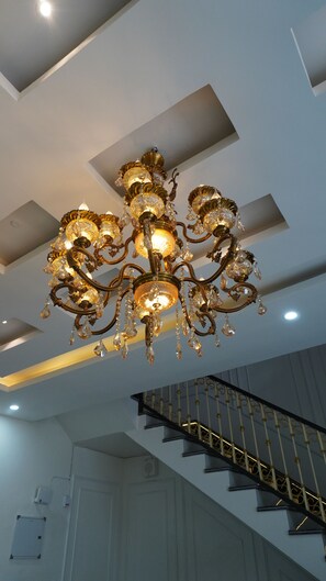 A chandelier with multiple arms and crystal decorations. - Macpro Inn Rubystone Express  (Dehradun)