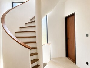 A spiral staircase with wooden steps and a white wall. - Villa Elora - Bingin Pecatu (Pecatu)