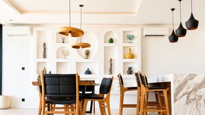 Ein moderner Essbereich mit Holzstühlen und einer Wand in Marmoroptik.
