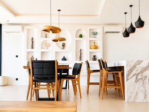 Ein moderner Essbereich mit Holzstühlen und einer Wand in Marmoroptik.