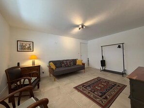Ein Wohnzimmer mit Sofa, Sesseln, einem Teppich, einer Lampe und einem Bild an der Wand.