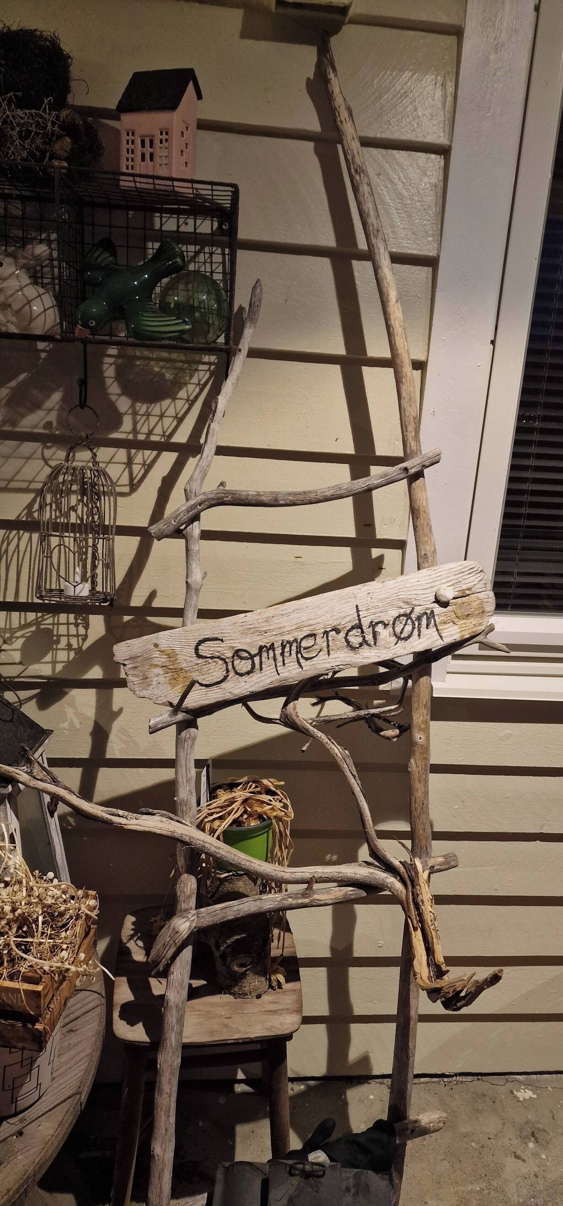 A wooden sign with the inscription 'Sommerdrom' attached to a wooden structure.