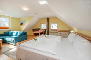 Une chambre à coucher comprenant un lit, un canapé, une table à manger et une chaise.