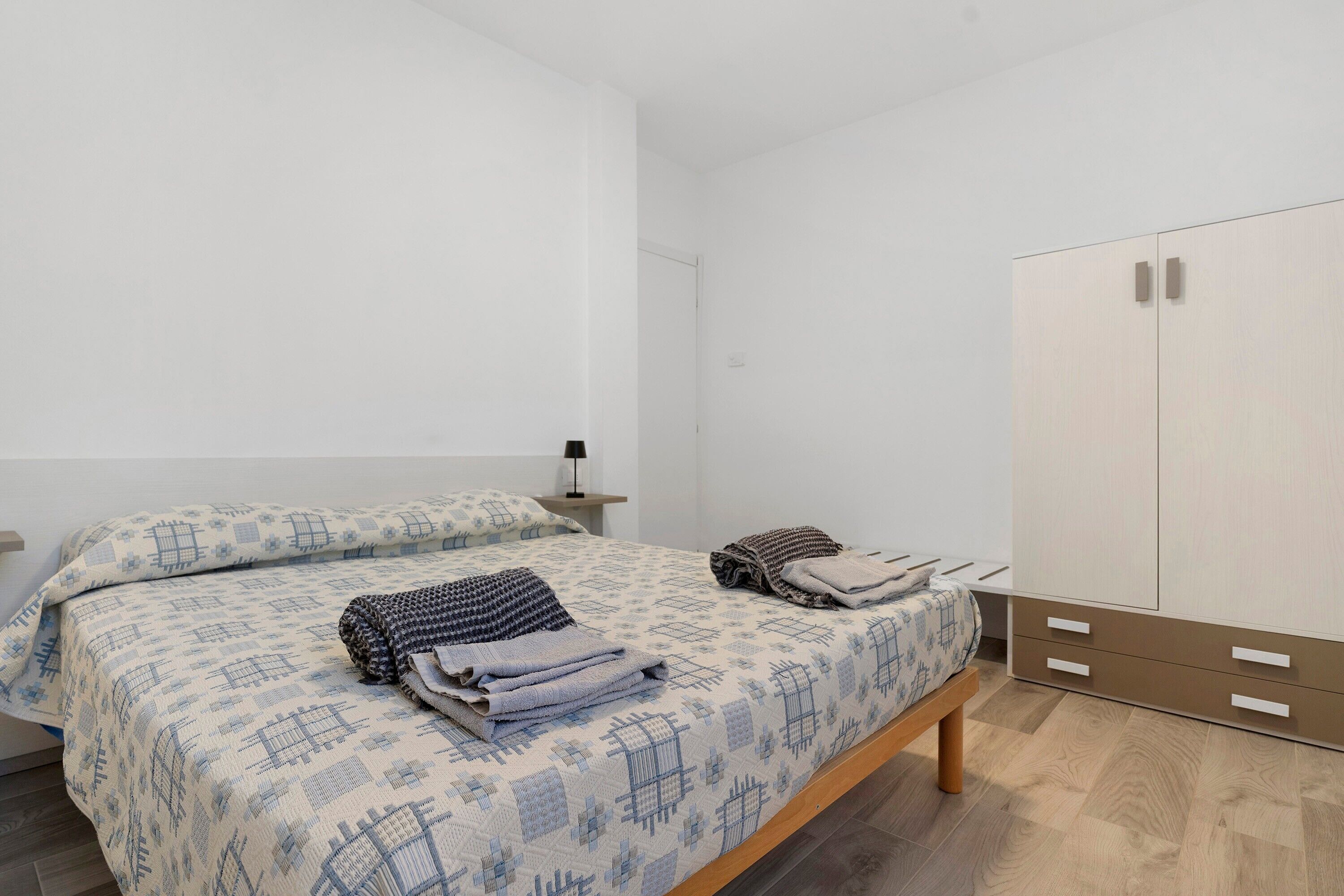 Une chambre à coucher comprenant un lit, une table de chevet, une armoire et une commode.