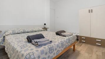 Une chambre à coucher comprenant un lit, une table de chevet, une armoire et une commode.