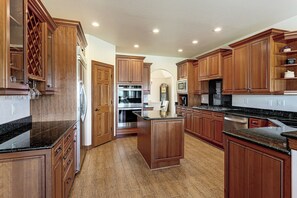 A spacious kitchen with wooden cabinetry, stainless steel appliances, and a central island. - Mtn Getaway Near Air Force Academy w/ Hot Tub (Colorado Springs)