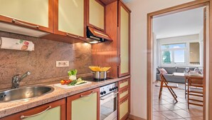 A kitchen with a granite countertop, stainless steel sink, and a built-in oven. - Hendrik Vittoriale Lake View Shared Pool (Gardone Riviera)