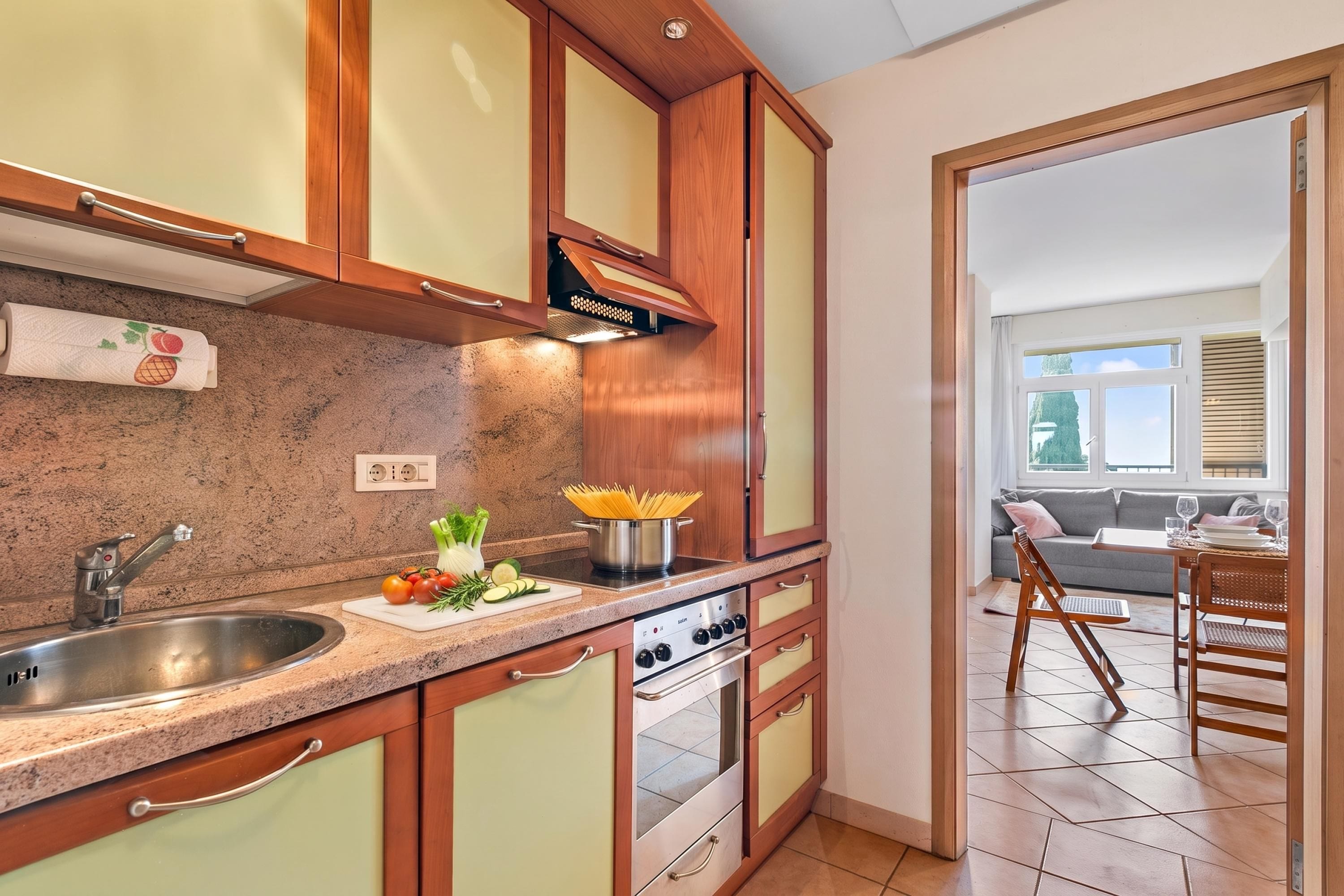 A kitchen with a granite countertop, stainless steel sink, and a built-in oven.