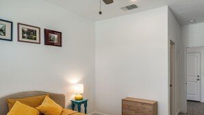A bedroom with a bed, a nightstand with a lamp, a dresser, and two framed pictures on the wall. - 1BR Guest House w/ Private Entrance and Laundry (Bakersfield)