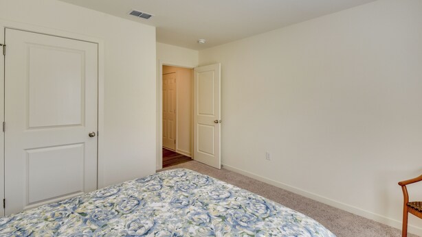 A bedroom with a bed, two doors, and a chair. - Lake Hartwell Home Base: 2 Mi to Marina! (Hartwell)
