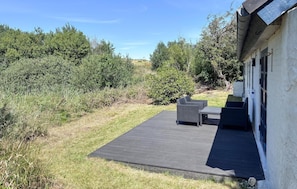 A patio area with a wooden deck, outdoor furniture, and a building with a white exterior. - Awesome home in Fur with house sea view (Fur)