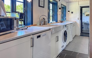 A modern kitchen with a built-in coffee maker, a washing machine, and a sink. - Awesome home in Fur with house sea view (Fur)