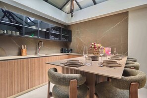 Una cocina moderna con isla integrada, paneles de madera y salpicadero de mármol.