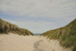 A sandy beach path flanked by grassy dunes leading to the sea. - Nordic cottage by Nationalpark Thy (Klitmøller)