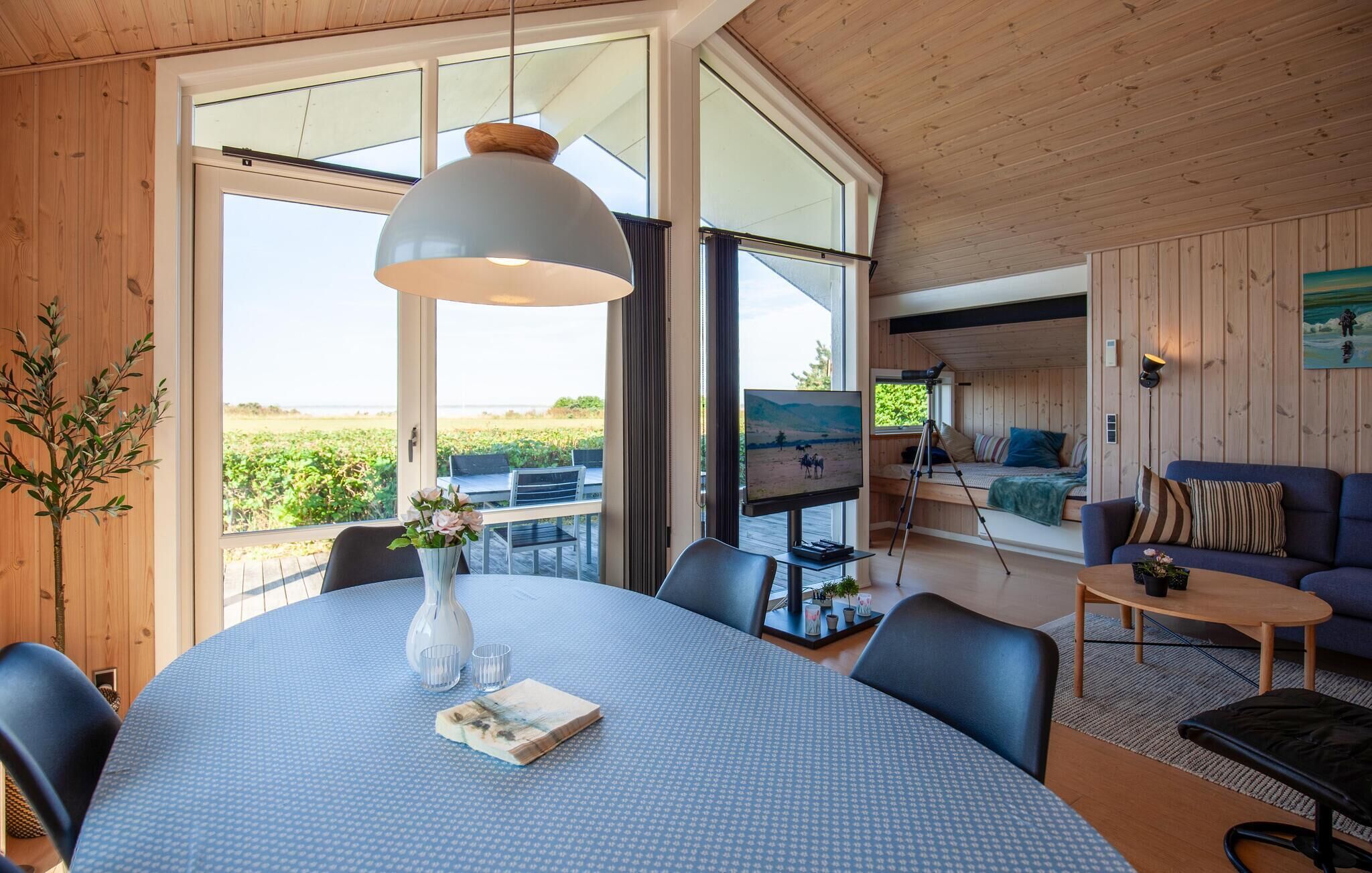 A spacious room with a large dining table, a comfortable seating area with a sofa, and a television.