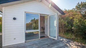 A modern house with a sliding glass door leading to an interior space. - Beach front home in Vestervig with WiFi (Vestervig)