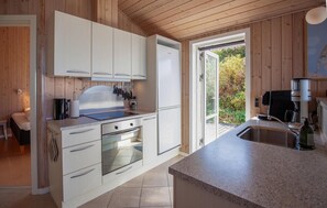 A modern kitchen with white cabinetry, a built-in oven, and a coffee machine. - Beach front home in Vestervig with WiFi (Vestervig)