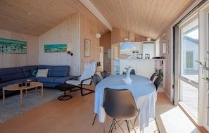 Um interior moderno com área de estar, espaço para refeições e cozinha.