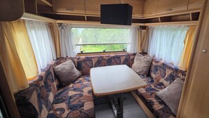 A cozy RV interior with a sofa set, a table, and curtains.